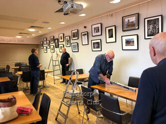 club members hanging the photos for exhibition